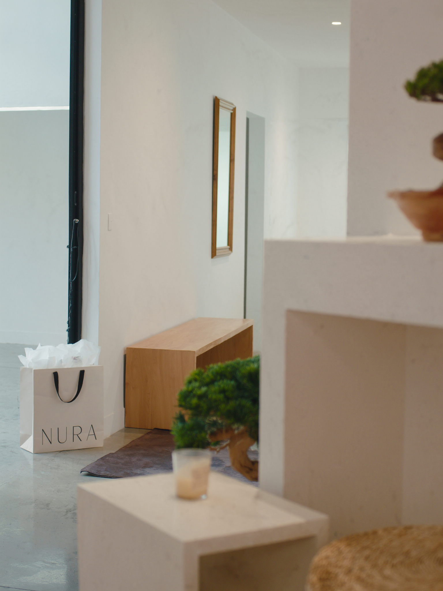 NURÁ reception with shopping bag